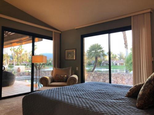 Schlafzimmer mit einem Bett und einer Glasschiebetür in der Unterkunft A Greenday Property: LAKEVIEW RETREAT: 2 lg En-Suite Master Bedrooms, Private Pool, Hot Tubs! in Rancho Mirage