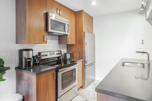 a kitchen with stainless steel appliances and wooden cabinets at Whistler Studio Next 2Lifts W/Free Parking in Whistler