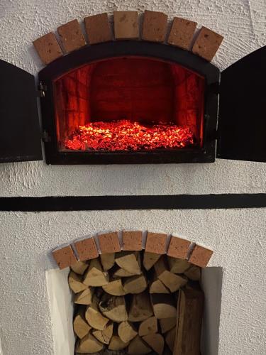 a brick oven with a pile of logs in it at Pompa Villa in Galyatető