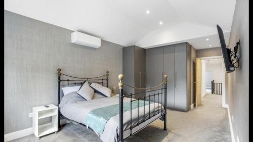 a bedroom with a bed and a tv in it at Newly refurbished 3 bedroom property in north london in East Barnet
