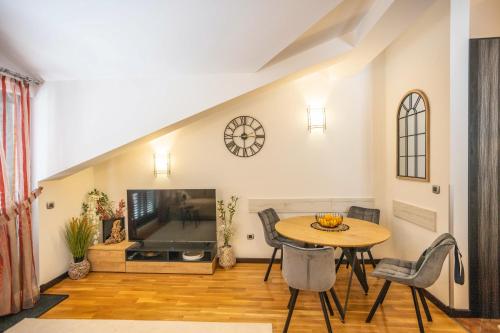a living room with a table and a tv at Sunny Portside Apartment in Ðenovići