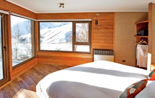 ein Schlafzimmer mit einem Bett und einem großen Fenster in der Unterkunft La Cornisa Lodge in Santiago