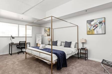 1 dormitorio con cama con dosel y escritorio en TWO Indy Modern Apartments by CozySuites, en Indianápolis