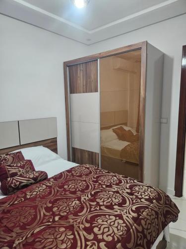 1 dormitorio con 1 cama y puerta corredera de cristal en Appartement moderne près de la corniche, en Nador