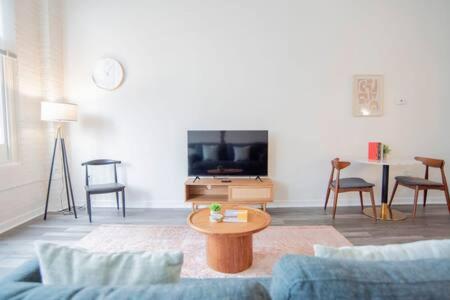 a living room with a blue couch and a tv at 3BR CozySuites at The Block Pool Table and Arcade in Indianapolis