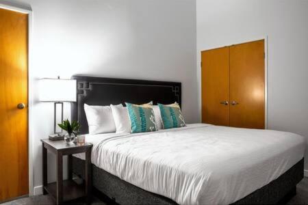 a bedroom with a large bed with a wooden headboard at TWO Bold 2BR 2BA Apartments by CozySuites in Indianapolis