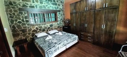 プエルトイグアスにあるPosada de Anaの石壁のベッドルーム1室(ベッド1台付)
