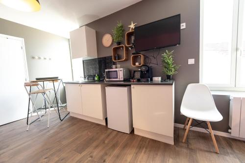 une cuisine avec des placards blancs et un comptoir avec un four micro-ondes dans l'établissement KASA LOUNGE - Climatisation - Au calme, à Rive-de-Gier