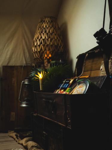 a room with a wooden dresser with a lamp and a pineapple at L'Insolite, Suite safari d'exception à Saumur in Saumur