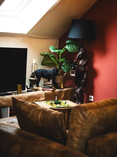 a living room with a couch and a table with a plant at L'Insolite, Suite safari d'exception à Saumur in Saumur