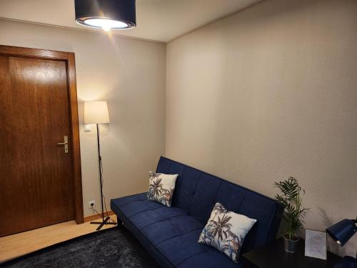 ein Wohnzimmer mit einem blauen Sofa und einer Holztür in der Unterkunft Appartement secteur Cathédrale in Straßburg