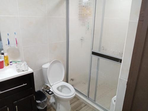 uma casa de banho com um WC e uma cabina de duche em vidro. em Casa en Tijuana Centro em Tijuana