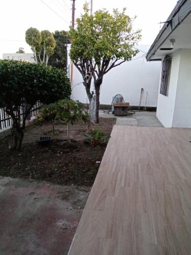 uma passagem de madeira em frente a uma casa com árvores em Casa en Tijuana Centro em Tijuana