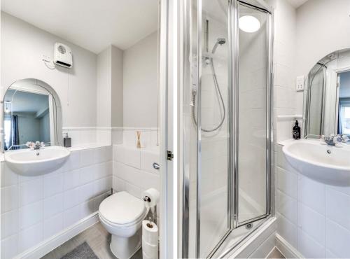 a bathroom with a shower and a toilet and sink at Welwyn Garden City Apartment by Mantis in Welwyn Garden City