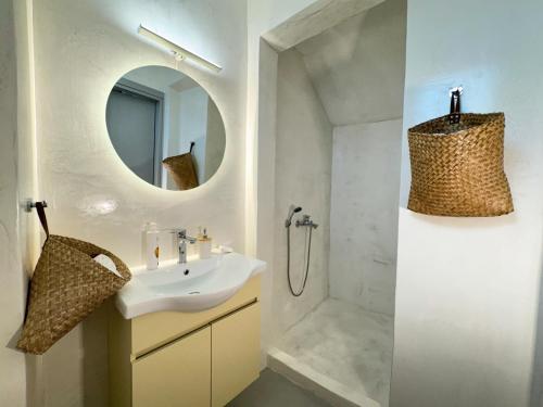 a white bathroom with a sink and a mirror at Èar in Ermoupoli