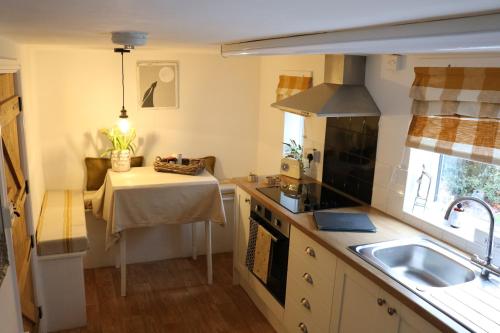 a small kitchen with a table and a sink at Hectors house in Ormesby Saint Michael
