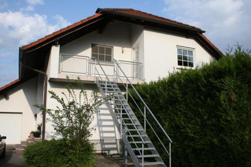 a white house with a staircase leading up to it at Chefs Gästezimmer in Neupotz