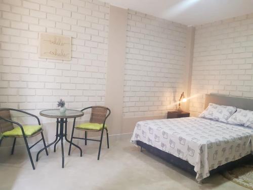 a bedroom with a bed and a table and chairs at Casa - Hospedaje Munay Ki - Yoga - in Pisco