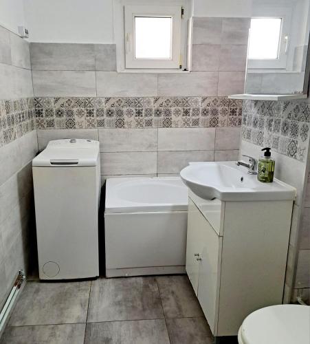 La salle de bains est pourvue d'un lavabo, d'une baignoire et de toilettes. dans l'établissement Apartament Elegant - Zona Alfa, à Arad