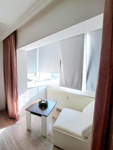 a living room with a white couch and a table at Apartament Elegant - Zona Alfa in Arad