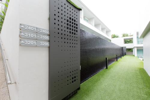 an external wall of a building with green grass at Sugar Palm Grand Hillside - SHA Plus in Kata Beach