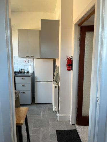 eine Küche mit weißen Geräten und einem weißen Kühlschrank in der Unterkunft Glebe Street Dumfries in Dumfries