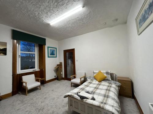 ein Schlafzimmer mit einem Bett und Stühlen in der Unterkunft Glebe Street Dumfries in Dumfries