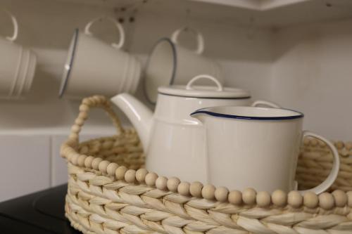 a basket with two coffee mugs on a table at Hectors house in Ormesby Saint Michael
