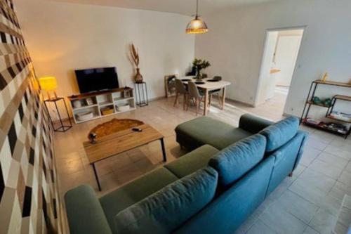 un soggiorno con un divano blu e un tavolo di Soleil d’ocre - Bastide à Roussillon a Roussillon