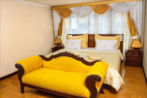 a bedroom with a yellow bed and a yellow couch at Hotel Senegal in Pasto