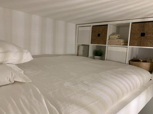 une chambre blanche avec un grand lit blanc dans l'établissement Joli studio coeur Montmartre 3F, à Paris