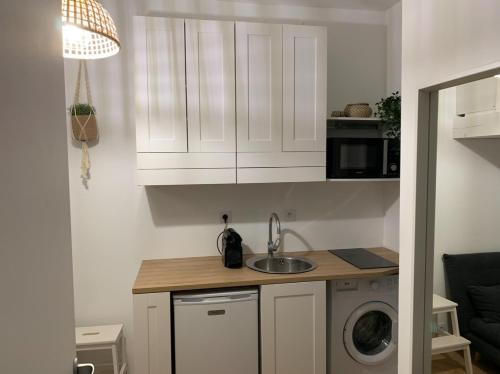 une cuisine avec un évier et une machine à laver dans l'établissement Joli studio coeur Montmartre 3F, à Paris