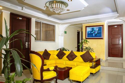 a living room with a yellow couch and chairs at Hotel Senegal in Pasto