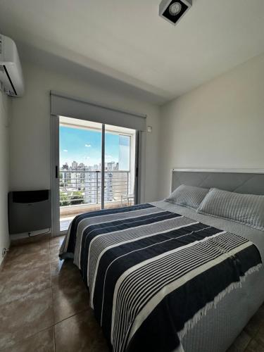 1 dormitorio con cama grande y ventana grande en Center Suites en La Plata