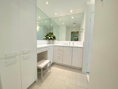 bagno bianco con lavandino e specchio di THE CROWN JEWEL: Luxurious Condo, 2 En-Suites, Stunning Views, Lg Patio! Managed by Greenday. a Rancho Mirage