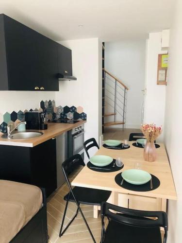 une cuisine avec un évier et une table avec des chaises dans l'établissement Charmette, à Dijon