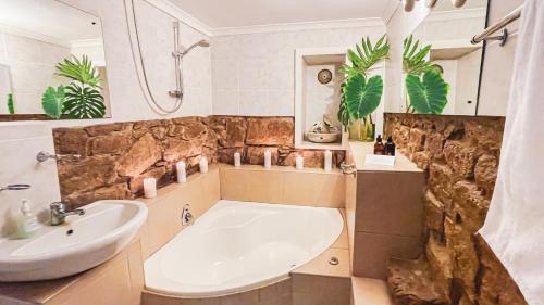 uma casa de banho com uma banheira e um lavatório em Picardie Guest Farm em Paarl