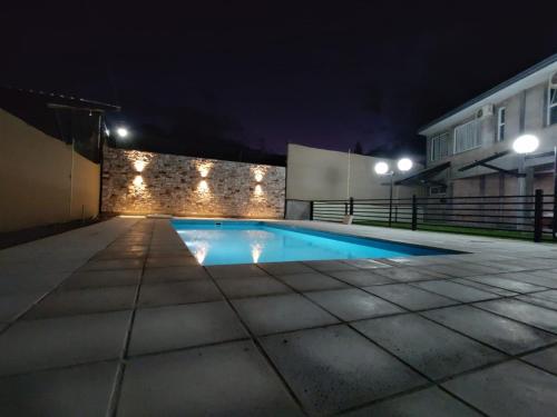 una piscina por la noche con luces en la pared en Soleado Apart Hotel en San Rafael