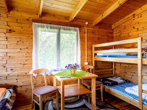 a bedroom with a table and bunk beds in a cabin at O.W. Sęk in Karwia