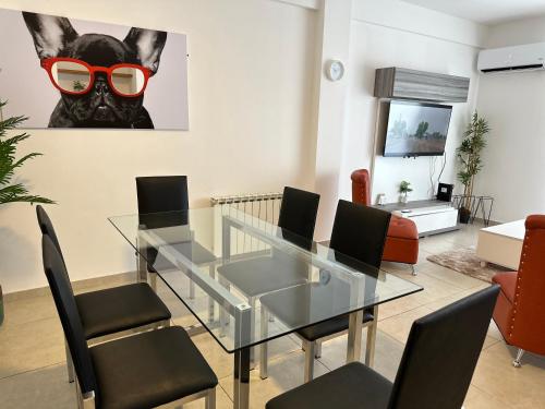 a dining room with a glass table with black chairs and a mask at Center Suites, 3 ambientes con cochera opcional in La Plata