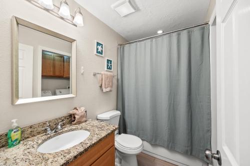 a bathroom with a shower and a sink and a toilet at Cozy 2-Bedroom Condo in Prime Siesta Key Location in Sarasota