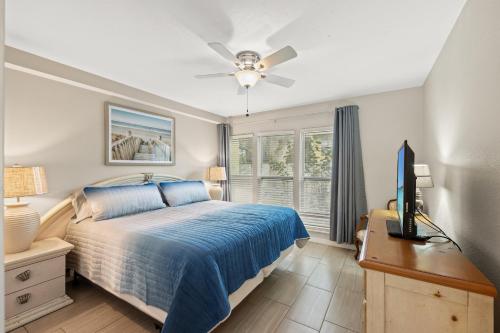 een slaapkamer met een bed, een bureau en een televisie bij Cozy 2-Bedroom Condo in Prime Siesta Key Location in Sarasota