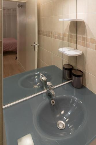 une salle de bain avec un lavabo bleu et un miroir dans l'établissement Parisian Romance Retreat, à Paris