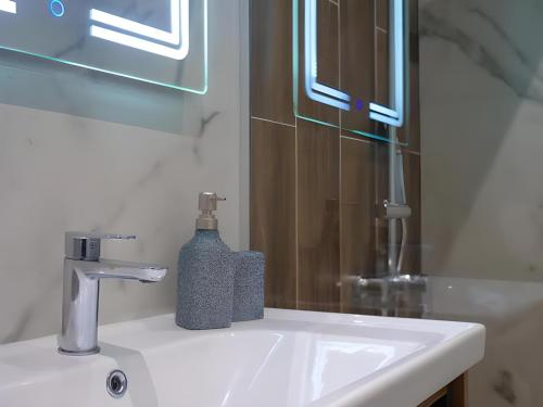 a bathroom sink with a bottle of soap on it at Elia Hotel Residence in Budva