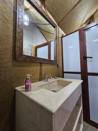 a bathroom with a sink and a large mirror at Najma Luxury Camp in Merzouga