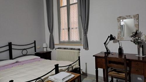 Schlafzimmer mit einem Bett, einem Schreibtisch und einem Spiegel in der Unterkunft Dietro le quinte nel cuore di Perugia in Perugia