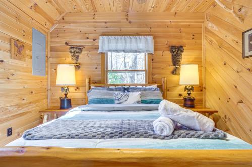 a bedroom with a bed in a log cabin at Quaint Dahlonega Cabin with Cavenders Creek Access! in Dahlonega