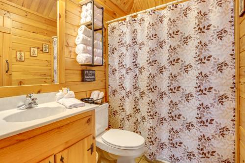 La salle de bains est pourvue de toilettes et d'un rideau de douche. dans l'établissement Quaint Dahlonega Cabin with Cavenders Creek Access!, à Dahlonega