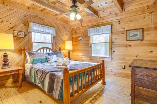 a bedroom with a bed in a log cabin at Quaint Dahlonega Cabin with Cavenders Creek Access! in Dahlonega