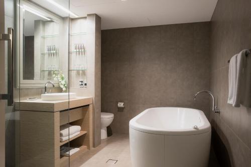 een badkamer met een toilet en een wastafel bij Novotel Melbourne On Collins in Melbourne